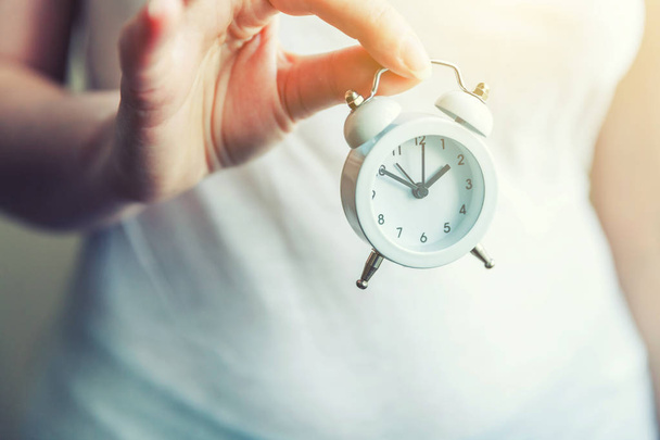 Mujer mujer manos sosteniendo timbre doble campana vintage reloj despertador clásico
 - Foto, imagen