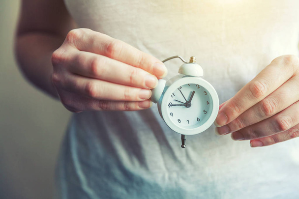 Mujer mujer manos sosteniendo timbre doble campana vintage reloj despertador clásico
 - Foto, imagen