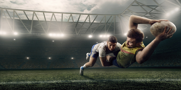 Two male Rugby players fight for the ball in flight on professional rugby stadium - Foto, Bild