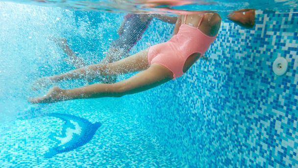 Imagen submarina de dos adolescentes buceando y nadando bajo el agua en la piscina
 - Foto, Imagen