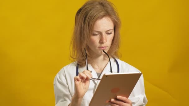 Young woman doctor. Yellow background. The concept of medicine. - Video, Çekim