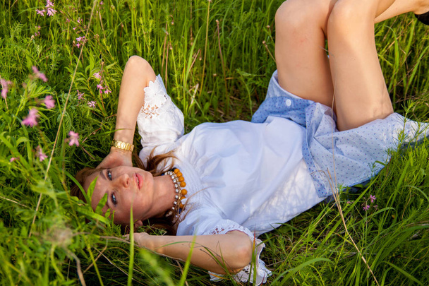 junge blonde Frau auf grünem Gras liegend, Freiheits- und Entspannungskonzept, Freiheits- und Entspannungskonzept, weicher Fokus, Vintage-Ton. - Foto, Bild