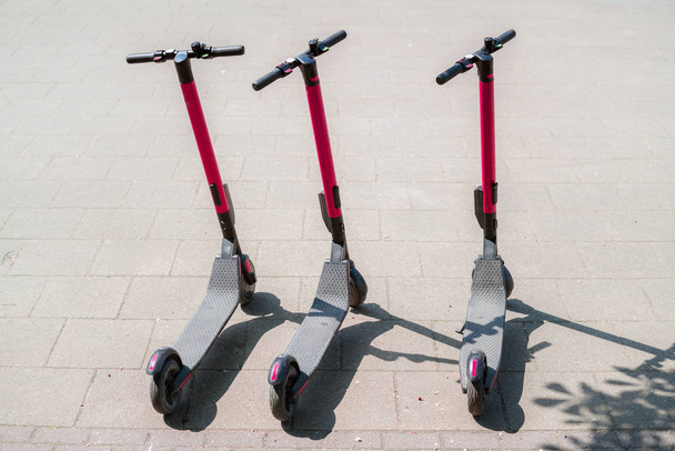 Scooters urbains éco-électriques modernes à louer à l'extérieur sur le trottoir. Tourisme alternatif, transport autour de la ville, service de remplacement de vélos. E-scooters peuvent être loués avec une application
 - Photo, image