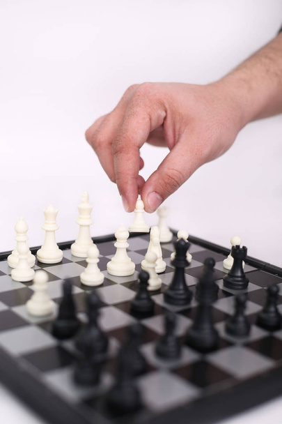 Portrait of man hand is playing chess. Isolated on the white background. - Foto, Imagen