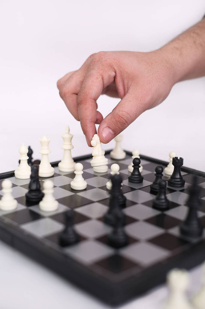 Man is playing chess. Isolated on the white background. - Foto, afbeelding