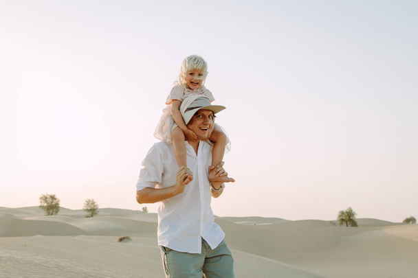Padre sosteniendo a su hijita en el desierto de Dubai
 - Foto, Imagen