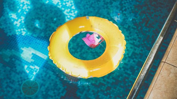 Close-up afbeelding van opblaasbare gele ring voor kinderen in zwembad - Foto, afbeelding