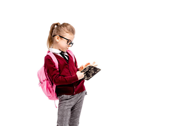 Child with schoolbag. Girl in white shirt and gray pants, rounde - Valokuva, kuva