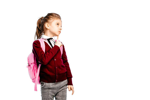 Child with schoolbag. Girl in white shirt and gray pants, hold a - Foto, Bild