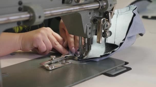 革製品を縫うプロセス。動いているミシンの針。ミシンの2本の針は、すぐに上下に移動し、クローズアップ。テーラーは縫製ワークショップで黒い革を縫う. - 映像、動画