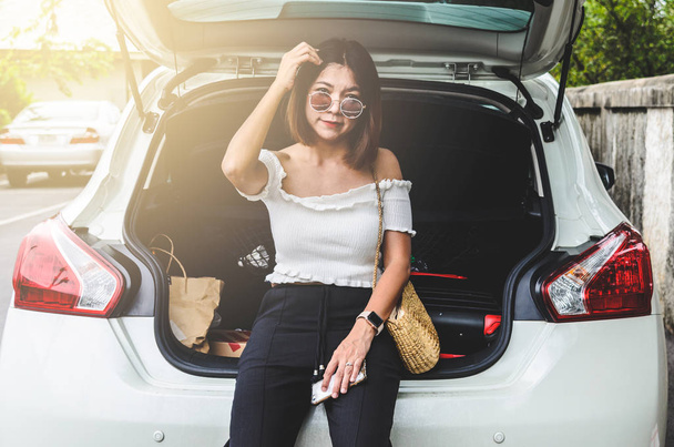 Woman sitting behind the car - Foto, Imagen