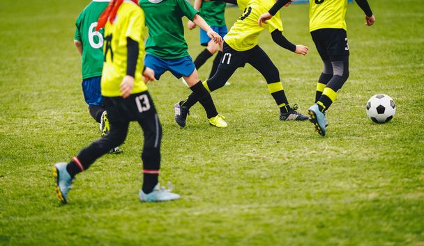 サッカーの背景。緑のフィールドでサッカーボールを蹴る選手。ユースチームのためのサッカートーナメントマッチゲーム - 写真・画像