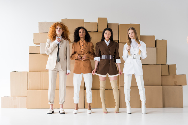 atractivo multicultural niñas posando cerca de cajas en blanco
  - Foto, Imagen