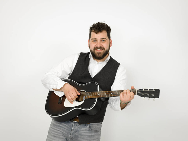 man with black hair and beard playing acoustic guitar on white background - Fotografie, Obrázek