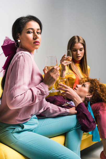 selective focus of african american girl near redhead and blonde women with champagne glasses on white  - Photo, Image