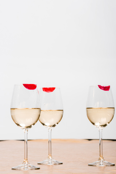 red lipstick prints on champagne glasses with alcohol on white  - Photo, image