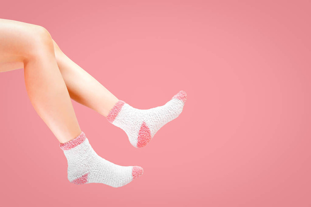 Beine einer Frau mit modischen Socken auf rosa Hintergrund. Wintersocken tragen. - Foto, Bild