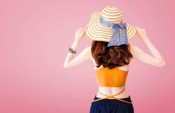 Mulher bonita usando um chapéu de palha e terno sexy no fundo rosa com conceito de verão
. - Foto, Imagem