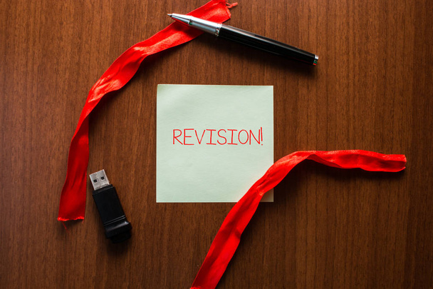 Text sign showing Revision. Conceptual photo action of revising over someone like auditing or accounting USB memory lying wooden table square blank note stripes ribbon up down pen. - Photo, Image