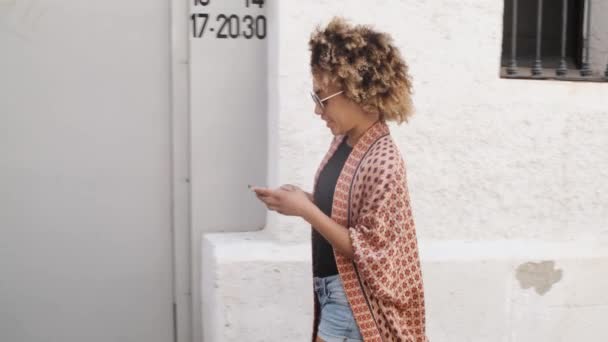 Elegante mujer negra con teléfono inteligente en la calle
 - Metraje, vídeo