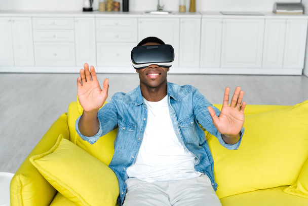 high angle view of happy african american man in vr headset sitting on couch - Fotoğraf, Görsel