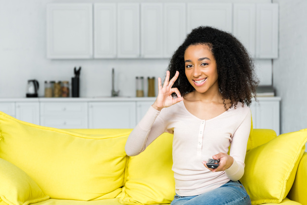 happy african american woman with remote controller showing ok sign - Foto, Bild