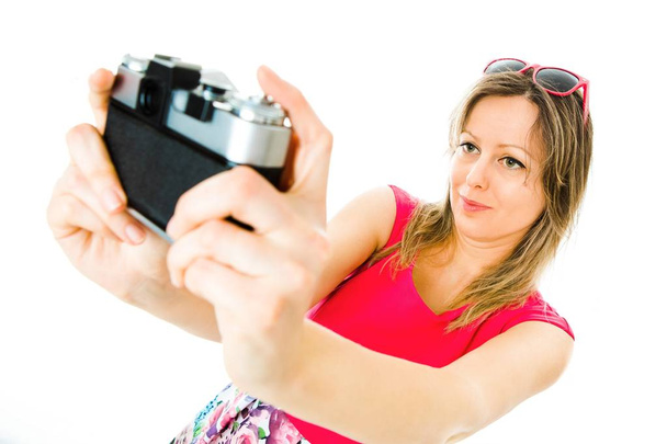 Uma mulher em vestido magenta com câmera analógica vintage selfie
 - Foto, Imagem