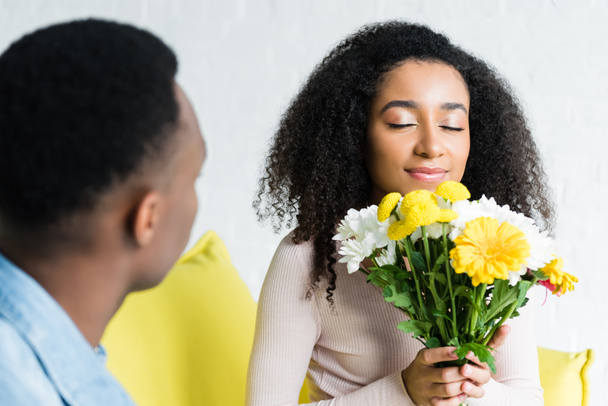 szelektív középpontjában afroamerikai nő gazdaság csokor virág - Fotó, kép