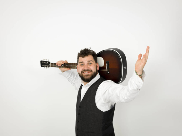homem com cabelo preto e barba posando com guitarra acústica em fundo branco
 - Foto, Imagem