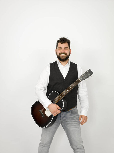 man with black hair and beard posing with acoustic guitar on white background - Valokuva, kuva