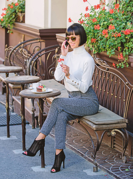 Pleasant time and leisure. Relax and coffee break. Woman attractive elegant brunette spend leisure cafe terrace background. Happy to hear you. Leisure concept. Girl fashionable lady with smartphone - Photo, Image