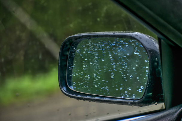 Espejo retrovisor. En el espejo hay gotas de agua después de la lluvia
. - Foto, Imagen
