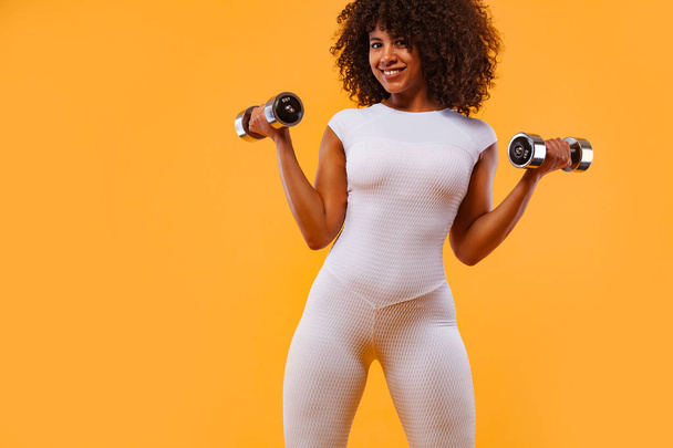 Sporty fit woman, athlete with dumbbells makes fitness exercising on white background. Fitness and workour motivation. - 写真・画像