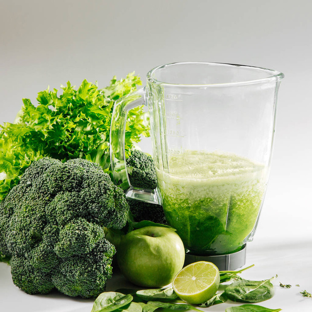 Healthy smoothies in a blender. Healthy food concept with spinach and green vegetables. Vegetarian food. - Foto, imagen