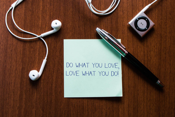 Почерк написания текста Do What You Love What You Do. Концепция означает, что вы в состоянии делать вещи, которые вам нравится работать в лучших местах, то верхний вид наушников музыкальное устройство и палку лежа деревянный
 - Фото, изображение