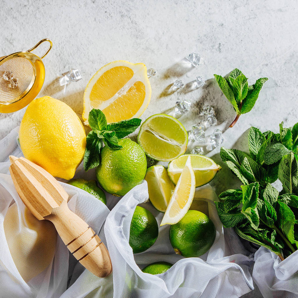 Cocktail making. Mint, lime, lemons ice ingredients and bar utensils. Flat lay, top view. - Photo, image
