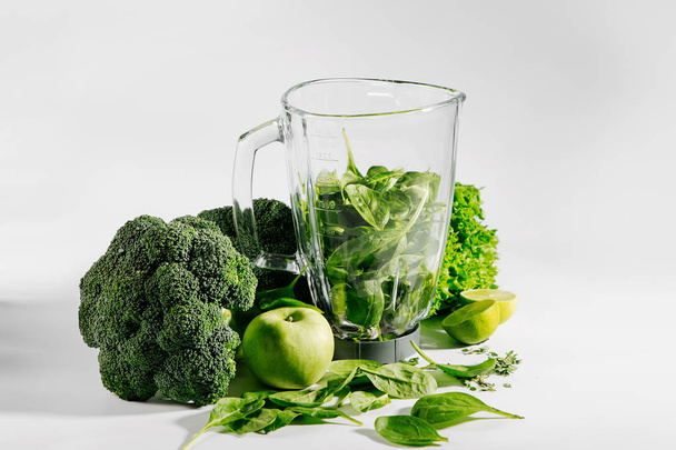 Ingredients for green smoothies in a blender. Healthy food concept with spinach and green vegetables. Vegetarian food. - Foto, Imagem