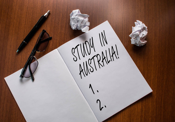 Käsitteellinen käsin kirjoittaminen osoittaa Study In Australia. Business valokuva teksti menee ulkomaille järjestyksessä suorittaa opinnot Notebook pieni ryppyinen paperi pallot lukulasit puinen pöytä
. - Valokuva, kuva
