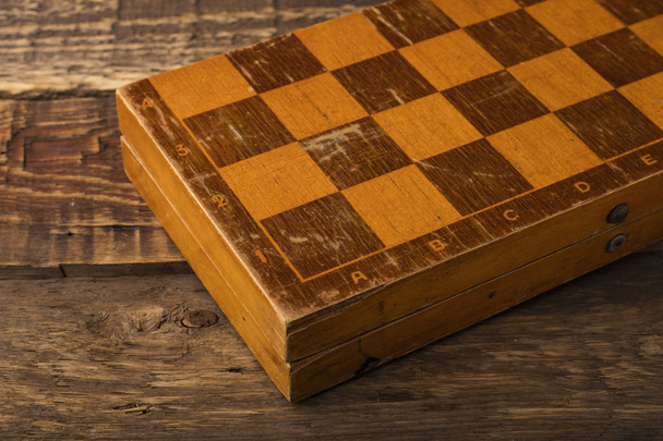 木製の背景に古いチェスボード。スペースのコピー - 写真・画像