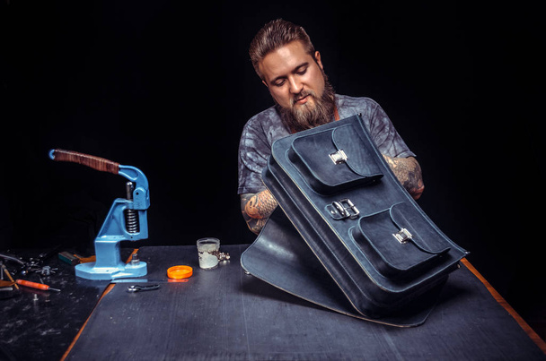 Lederkünstler stellt Lederwerkstück in Werkstatt her - Foto, Bild