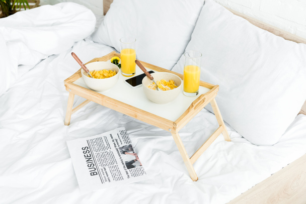 high angle view of table for breakfast on white bed in bedroom - Foto, Imagen