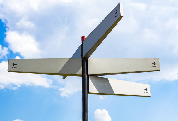 Blank signpost with many directions against blue sky in sunny day. Mockup. copy space - Foto, imagen