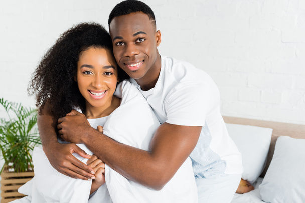 african american couple cuddling to each other and looking at camera - Foto, imagen