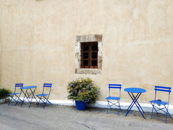 Calle antigua estrecha con pequeños cafés callejeros, Creta, Grecia
 - Foto, Imagen