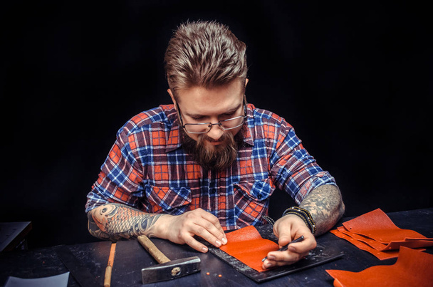 Καλλιτέχνης που δουλεύει με δερμάτινα με χρήση εργαλείων χειροτεχνίας  - Φωτογραφία, εικόνα