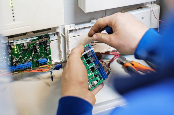 Specialist hands connect the wire to the Board with chips. Repair, maintenance and adjustment of instrumentation and equipment. - Φωτογραφία, εικόνα