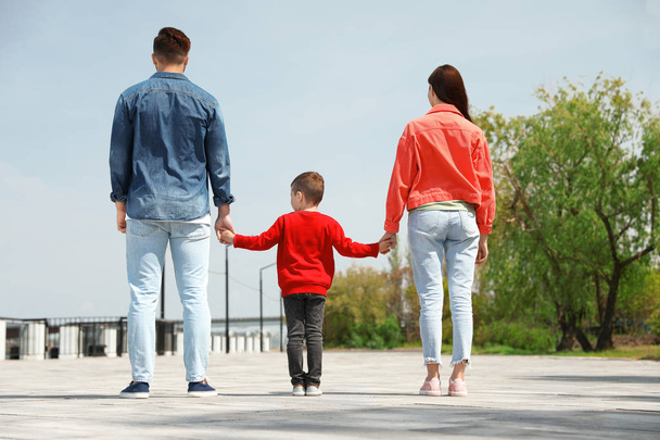 Little child holding hands with his parents outdoors. Family weekend - Photo, image