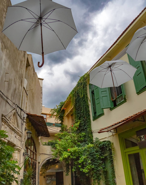 Πίσω οδός της μεσογειακής πόλης με καταπληκτικά στολίδια στο δρόμο και μεγάλα αμπέλια αναρρίχηση στα κτήρια-Κρήτη, Ελλάδα - Φωτογραφία, εικόνα