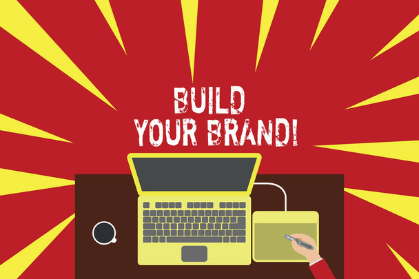 Szövegírás Build Your Brand. Üzleti koncepció létrehozza vagy javítja az ügyfelek ismereteit és véleményét a termék Felső nézet laptop fa íróasztal munkavállaló rajz tabletta kávécsésze iroda. - Fotó, kép