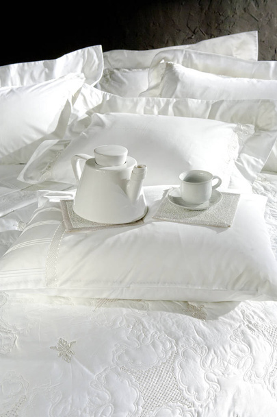 thé petit déjeuner sur le lit gros plan, couvertures blanches chic sur fond de mur noir
 - Photo, image
